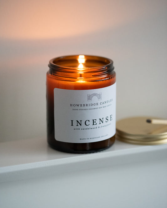 Candle labeled 'Incense' by Howebridge Candles on a white surface.