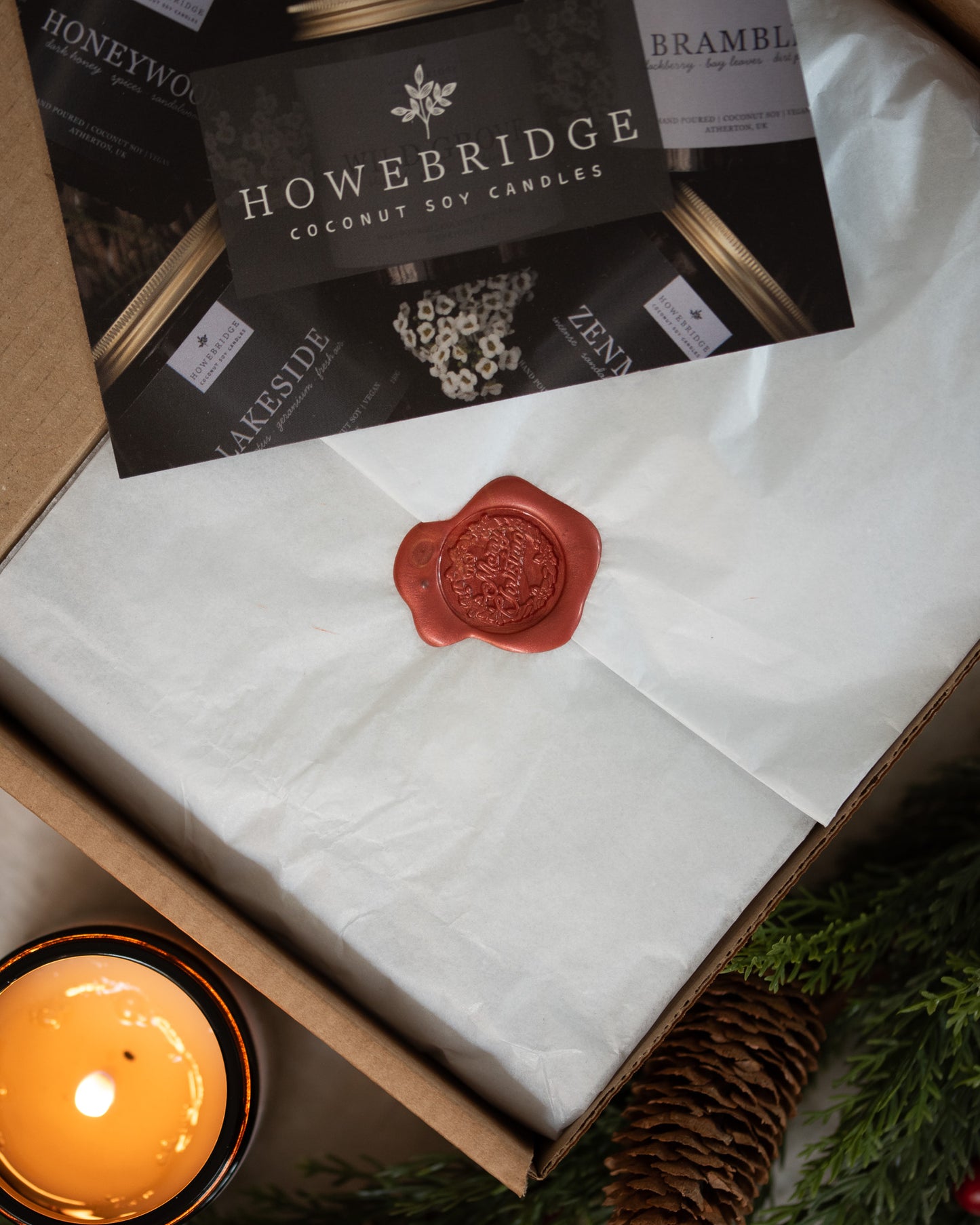 Howebridge Candles packaging, showing tissue paper sealed with a festive red wax seal and business card.
