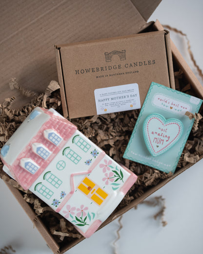 Howebridge Candles mother's day gift box. Featuring a pastel house ceramic wax burner, botanical soy wax box with a personalised label and a 'most amazing mum' wooden badge. All inside a kraft box with shredded kraft paper.