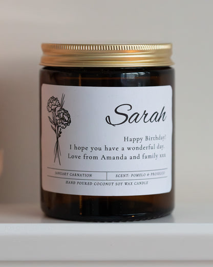 Personalised birthday birth flower candle gift by Howebridge Candles, features name, message and birth flower on glass amber jar and gold lid.