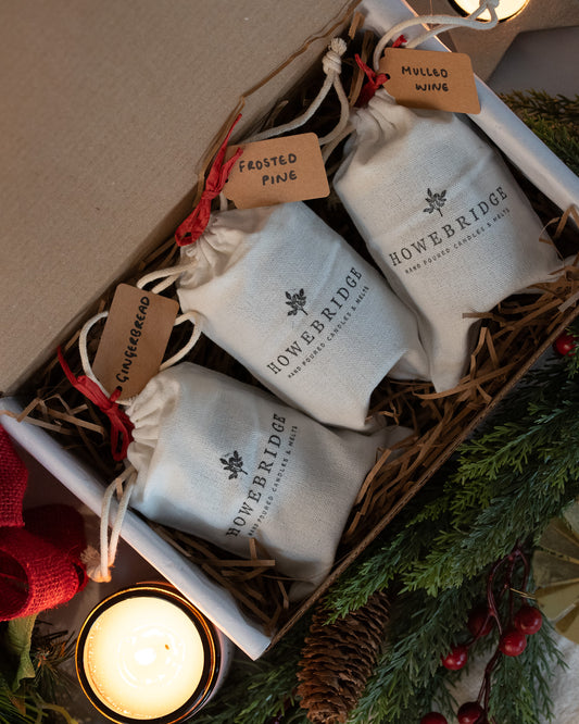 Howebridge trio of Christmas candles, gift wrapped in cotton drawstring bags and labeled. Scents of mulled wine, frosted pine and gingerbread. A lovely gift for a loved one this Christmas.