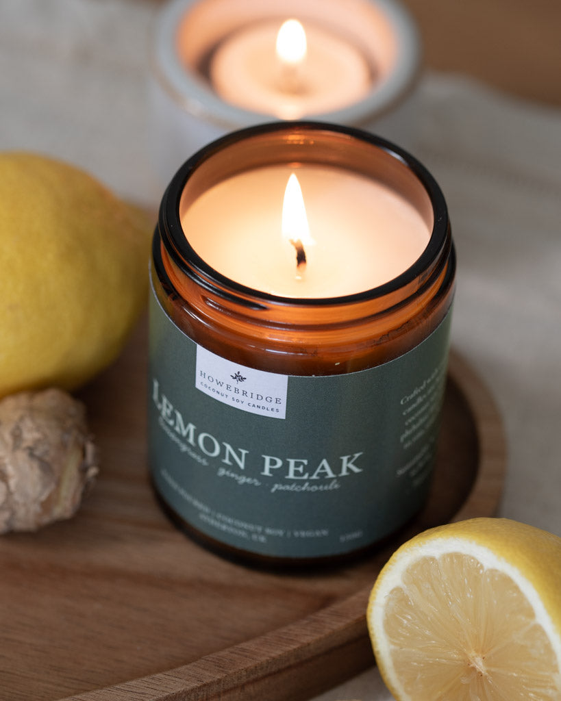 Lemon Peak candle lit and surrounded by lemons and ginger. Made using coconut soy wax and phthalate free fragrance oils. Sustainable luxury and vegan friendly. Scent: Lemongrass, ginger & patchouli.