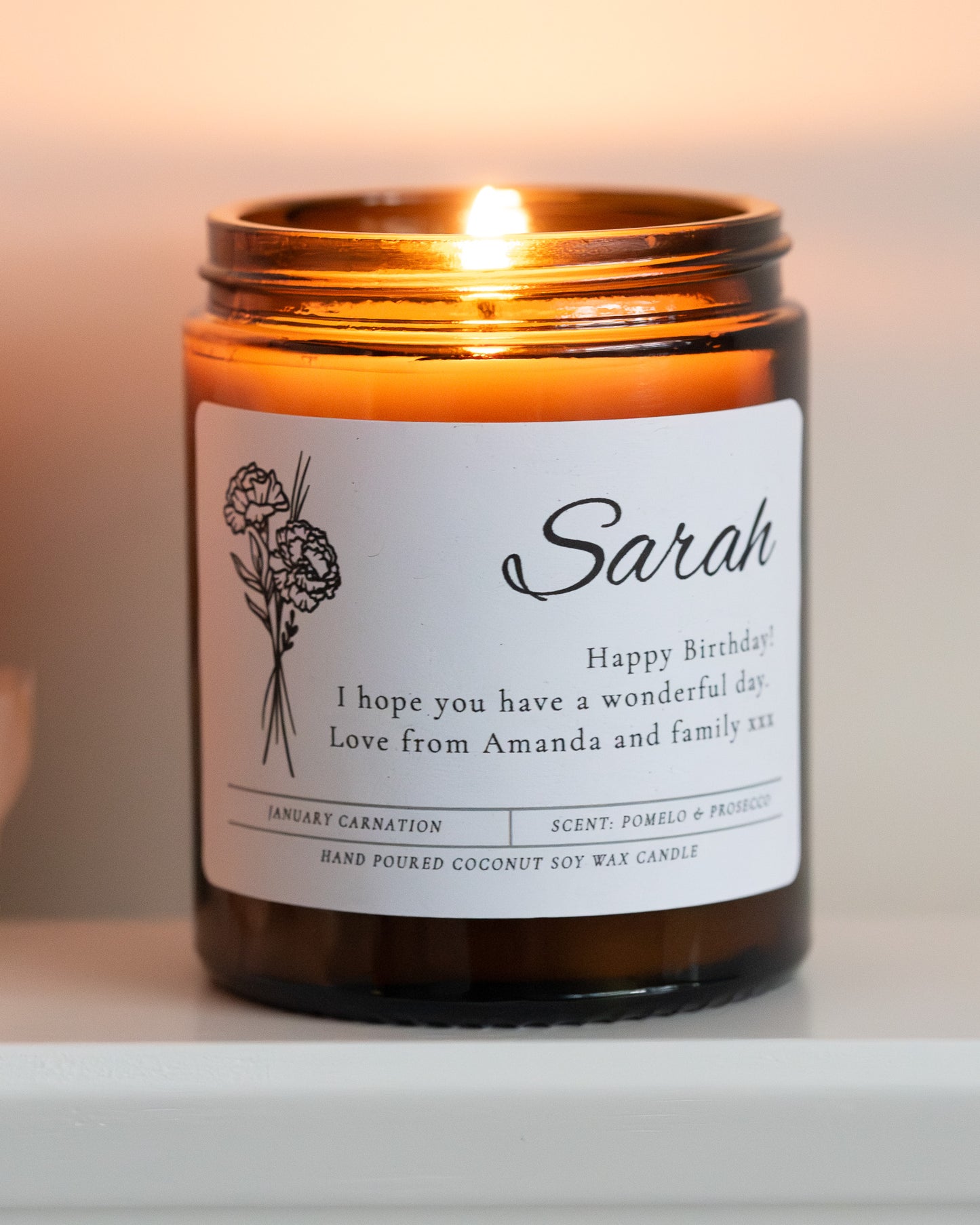 Personalised birthday birth flower candle gift by Howebridge Candles. Features name, message and flower on glass amber jar and gold lid.