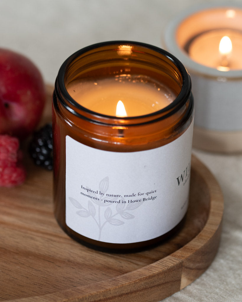 Rhubarb wild grove candle. Amber jar with natural wrap around label. Image is side of label and says, 'Inspired by nature, made for quiet moments - hand poured in howe bridge'. Scent: rhubarb, plum and blackberries. Our best selling rhubarb candle and a scent you will love all year through.