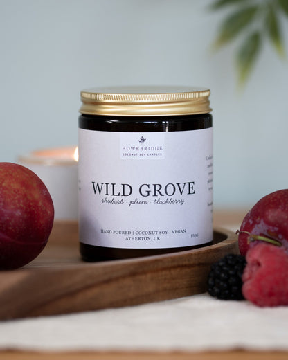 Wild grove candle surrounded by summer fruits. A glass amber jar with a natural off white label. Scent: Rhubarb, plum and blackberries. A sweet, fruity candles perfect for summer or a sweet pick me up.