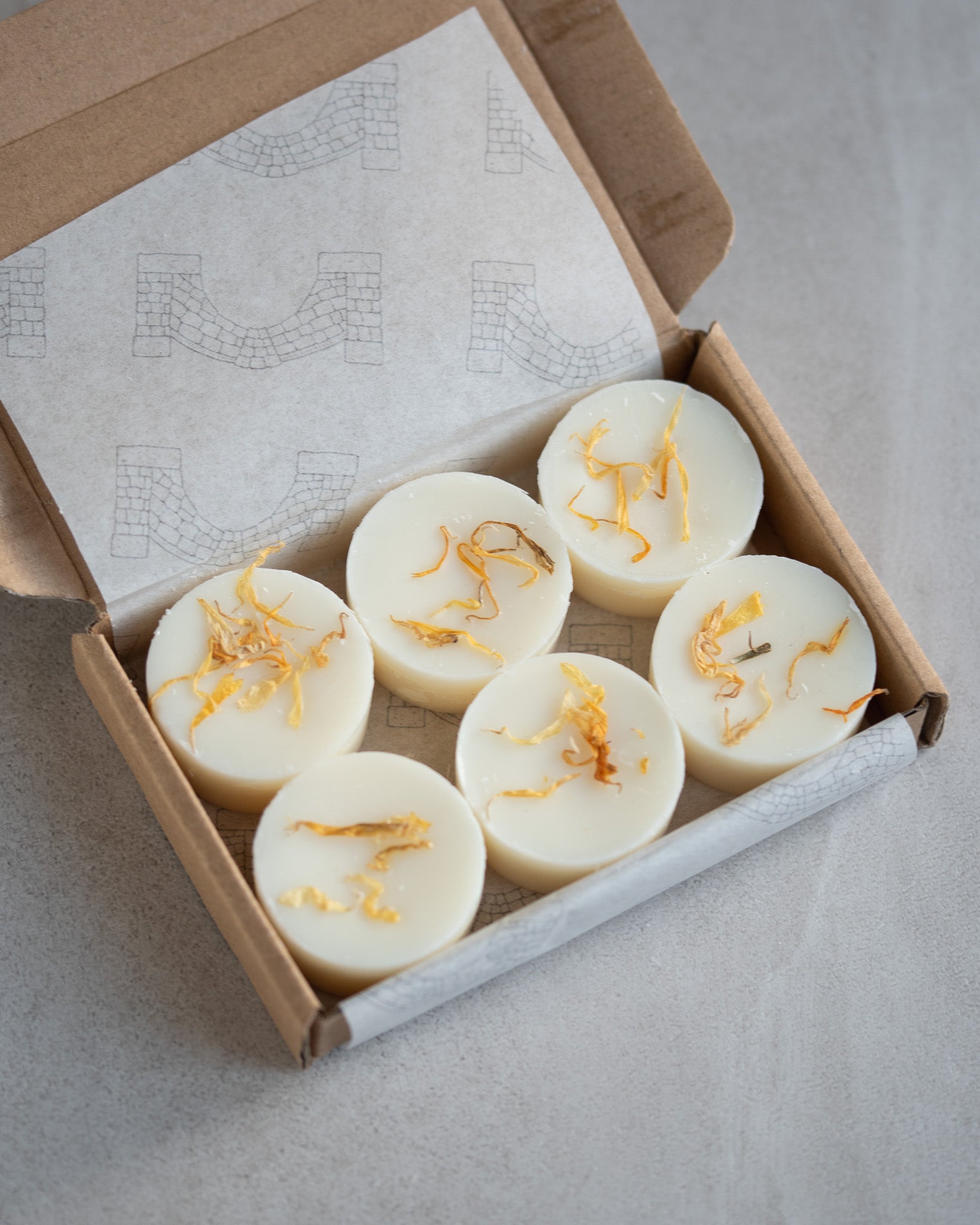 Open kraft box of 6 round botanical soy wax melts. Hand poured by Howebridge Candles