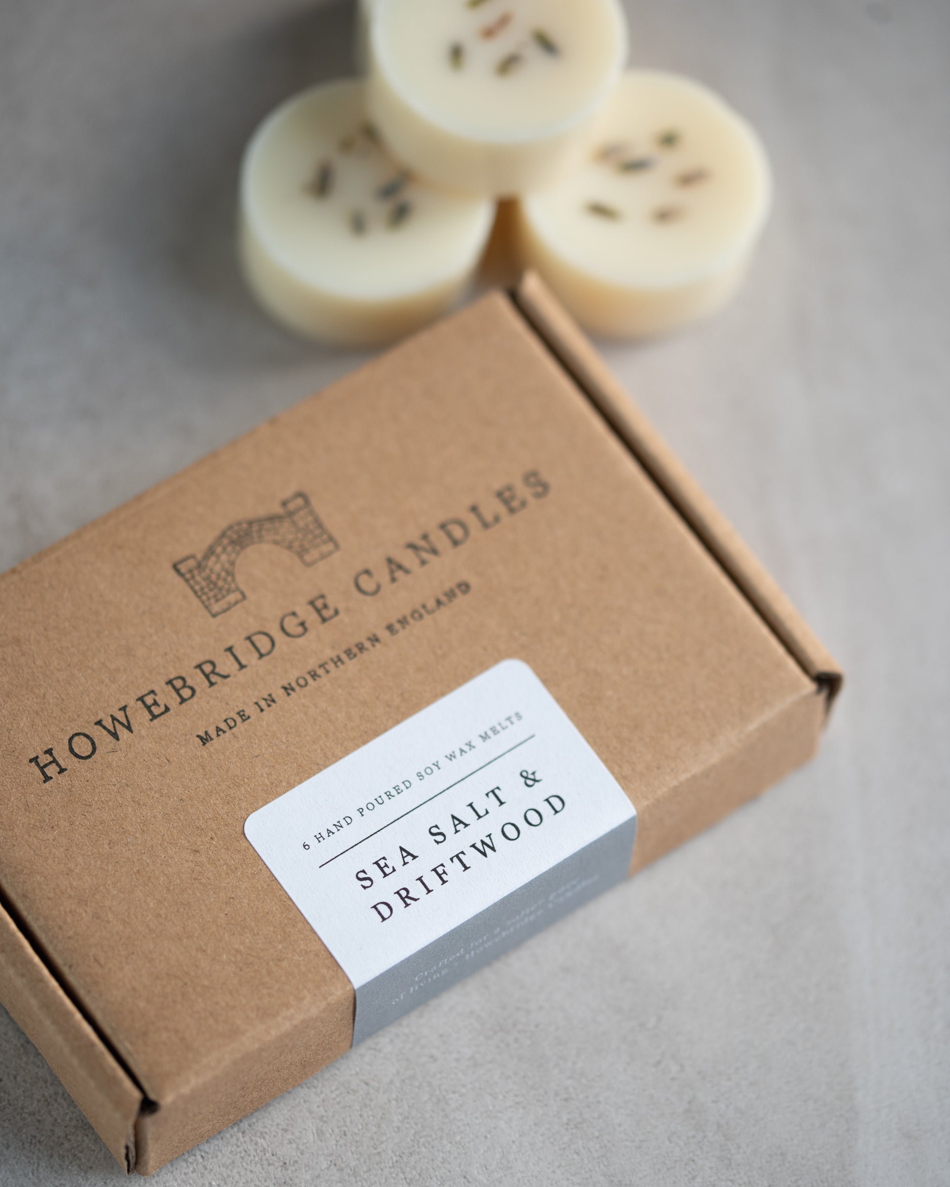 Howebridge Candles sea salt & driftwood wax melts inside a kraft box, stamped with their logo and sealed with a scent descriptive label.