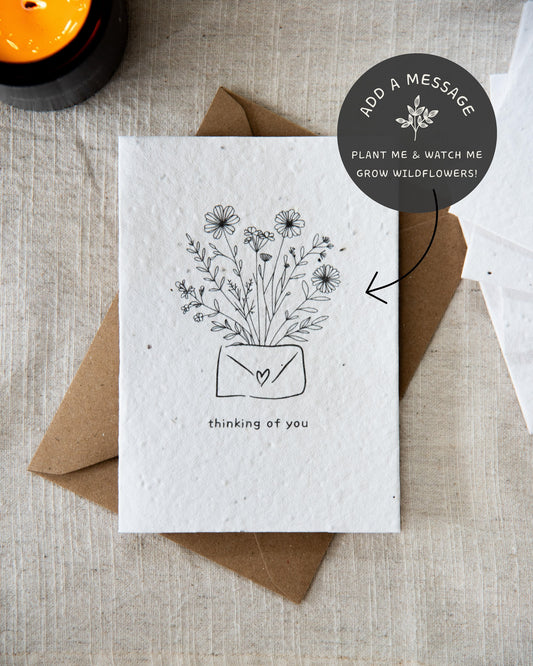 Wildflower plantable seed card with the message 'thinking of you' surrounded by botanicals. Printed on 100% cotton paper and complete with C6 Kraft envelope.